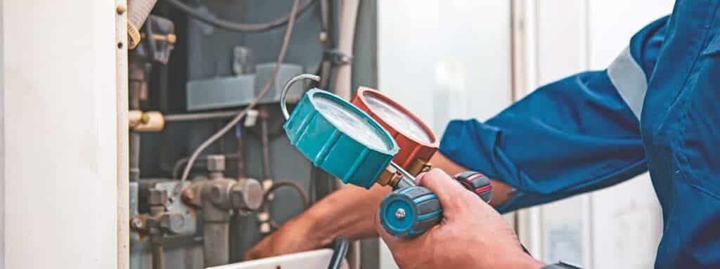 Technician checking refrigerant pressure with HVAC gauges