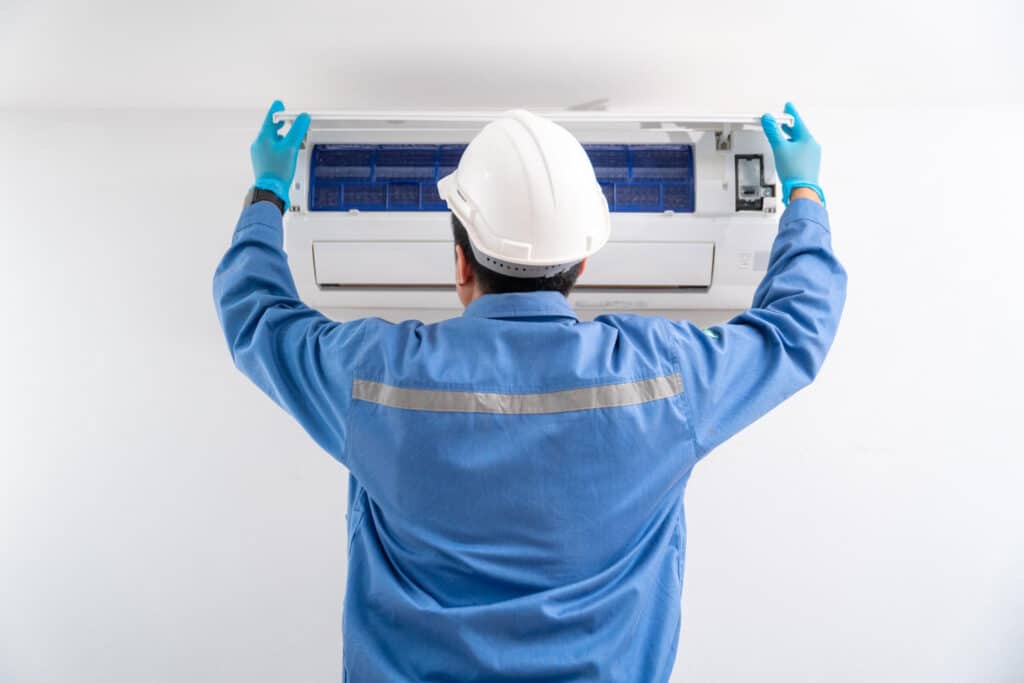 Technician servicing a wall-mounted ductless indoor unit